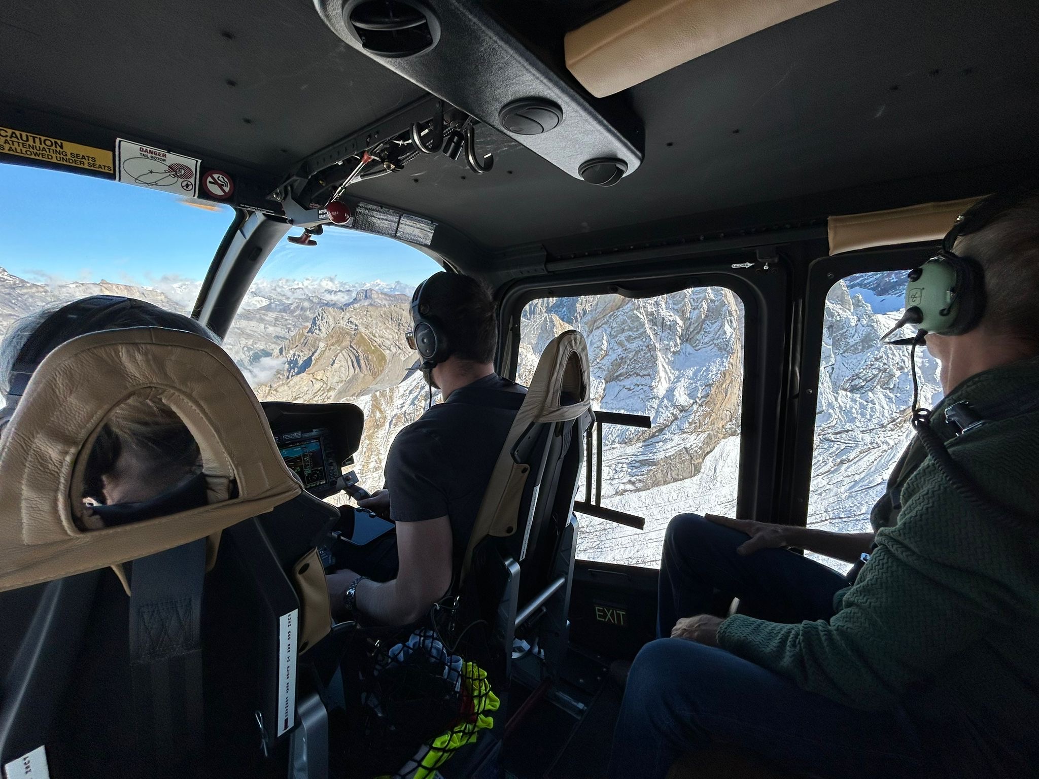 Intérieur de l’hélicoptère – passagers admirant les Alpes suisses – Heli3000