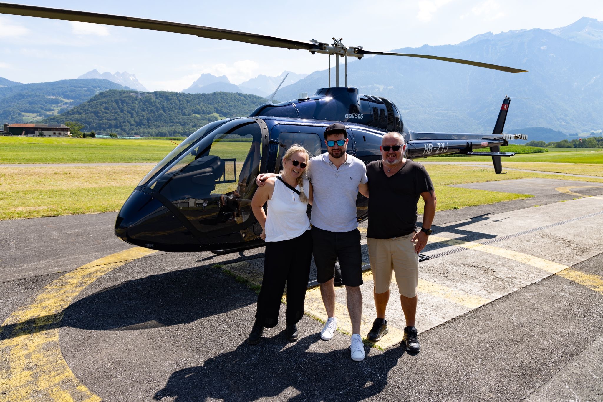 Passagers et pilote posant devant l’hélicoptère – Heli3000